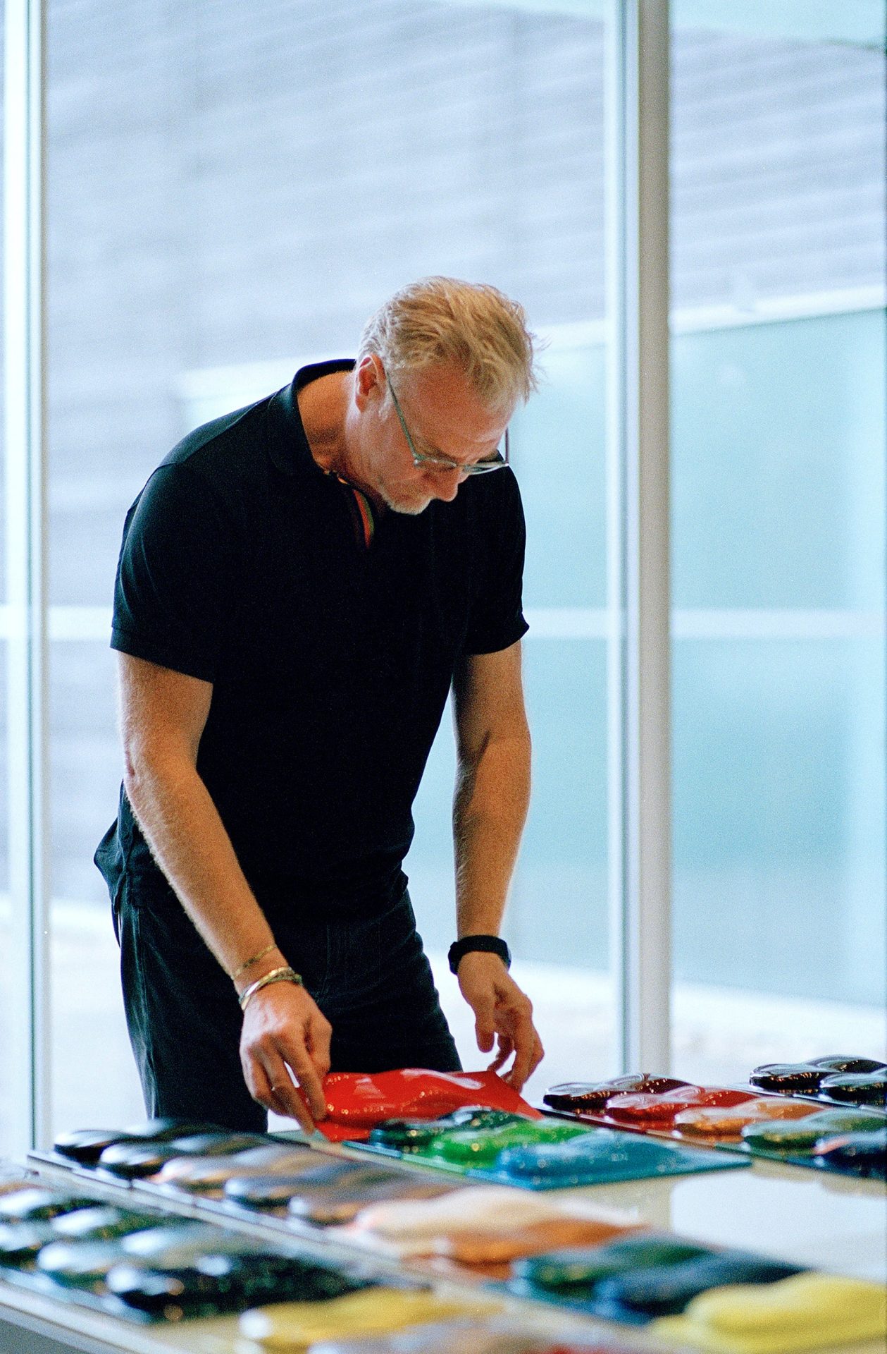 Marek studying car models in Obsessions: Design with Marek Reichman for A Collected Man London