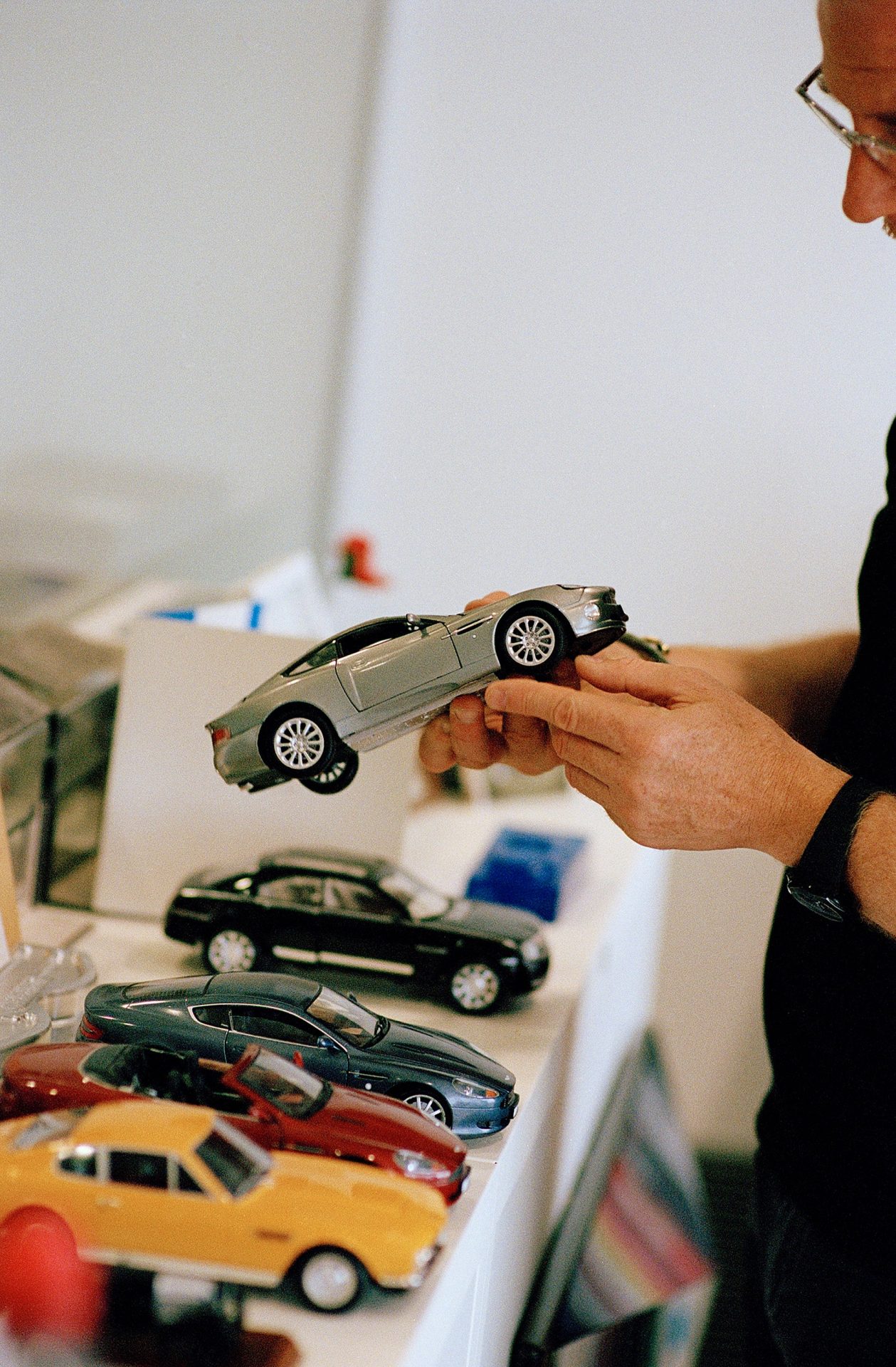 Marek Reichman Head of Creative at Aston Martin in his office with toy cars for A Collected Man London